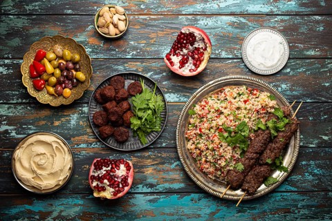 Various Turkish dishes: meat kebab with tabbouleh salad, falafel, hummus, olives, pistachios and