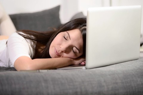 Tired woman fallen asleep over the laptop keyboard