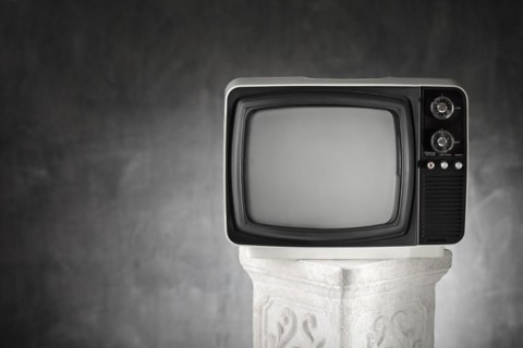 Old portable television on a plaster column