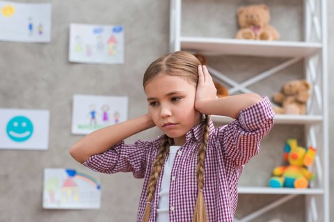 Portrait sad girl covering her ears with two hands