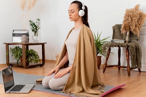 Woman meditating home with headphones