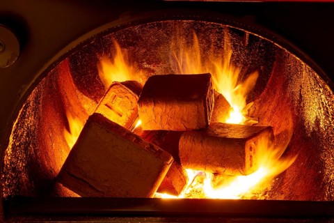 Wood briquettes (ruf type), made of beech and oak burning inside the wood fuel boiler. Alternative