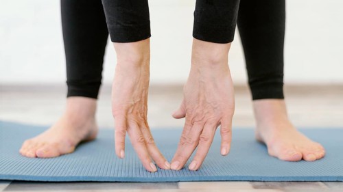 Close up hands touching yoga mat