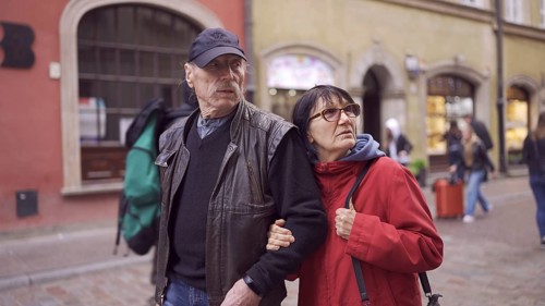 Elderly couple of tourists are walking through the historical center seeing the sights in an old