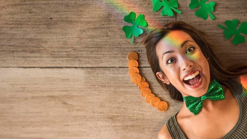 Crying woman near heap coins paper clovers floor