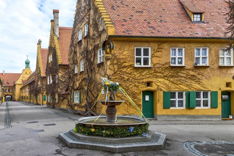Building in the historic residential complex Fuggerei and Fuggerei Brunnen in the old town of