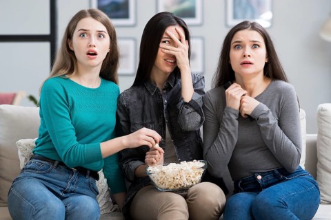 Group adult women watching horror movie