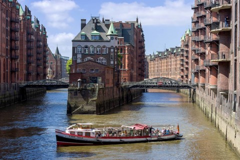 Launch with tourists and moated castle behind it, moated castle in Hamburg's Speicherstadt,