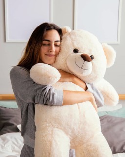 Woman home embracing big teddy bear