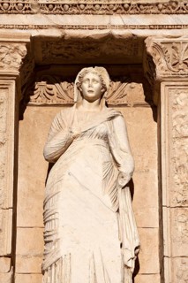 Ancient marble statue of a woman looks out under intricate archway copy space (statue is Sophia)