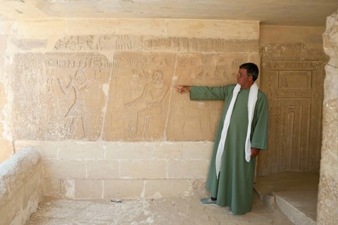Tourist guide shows relief in Mastaba, near Sakkara, Egypt, Africa
