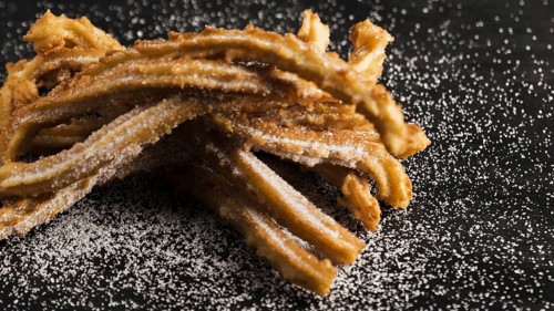 Delicious fried churros with sugar high view. High resolution photo