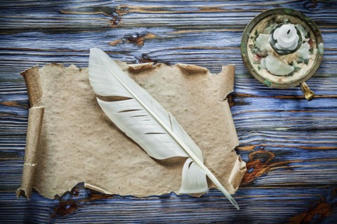 Vintage paper scroll feather chandelier on blue wooden background