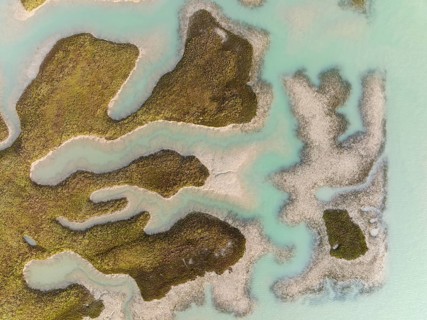 Patches of land appear while the tide is going out, in the marshland of the Bahía de Cádiz, aerial