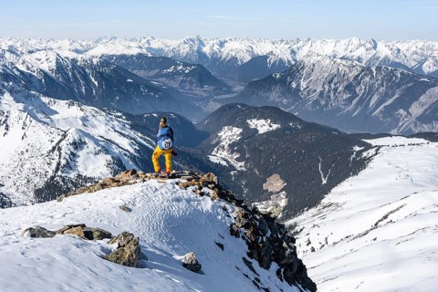 View of the Inn Valley, mountaineer at the summit of the Pirchkogel, mountains in winter,