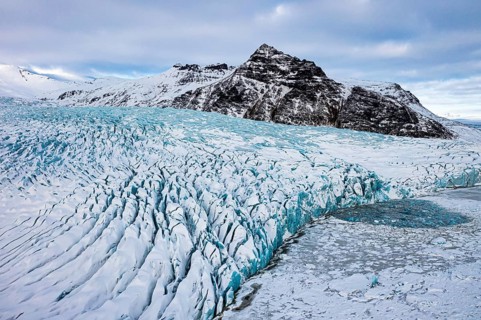 Snow-covered icebergs in the Fjallsarlon glacier lagoon, with the Öraefajökull glacier behind,