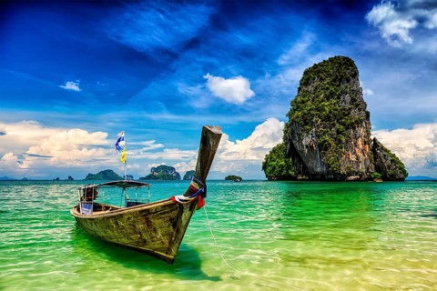 Long tail boat on tropical beach (Pranang beach) and rock, Krabi, Thailand, Asia