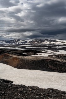Snow-covered volcanic landscape with volcanic sand and petrified lava, crater of Askja volcano,