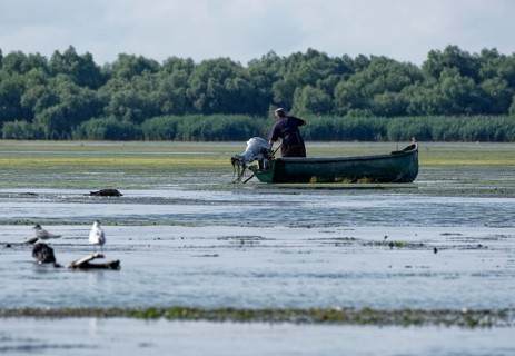 Fishermen in a boat on the water of Lacul Isaccel, a lake in the Danube Delta. UNESCO Danube Delta