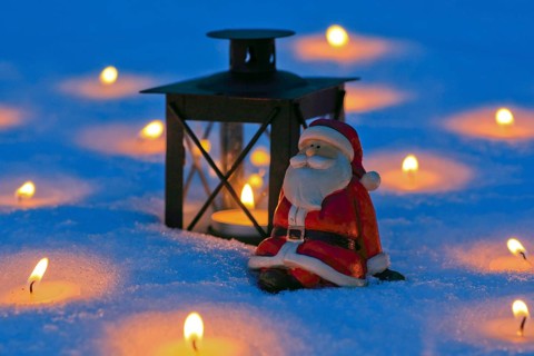 Santa Claus and lantern in the snow, with burning candles