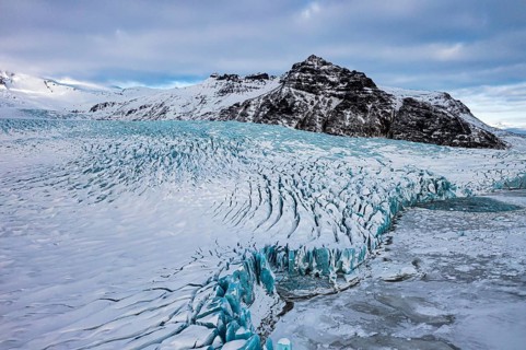 Snow-covered icebergs in the Fjallsarlon glacier lagoon, with the Öraefajökull glacier behind,