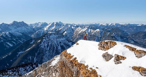 Ski tourers at the summit of Schafreuter, view of snowy mountain panorama, Karwendel, Tyrol,