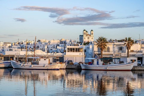 View of Naoussa, Fishing boats in the harbour at sunset, reflected in the sea, White Cycladic