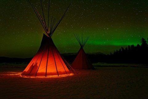 Two tents, tipis, Indian tents, front one illuminated from the inside, in a winter landscape,