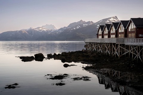 Typical wooden houses (rorbuer) on wooden stilts at Hestnes Bay (Hestnesbukta) . At night at the