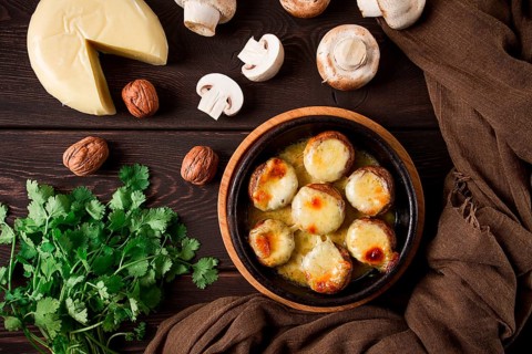 Traditional Georgian dish, appetizer, stuffed mushrooms, Sulguni cheese, baked in a Ketzi clay pan,