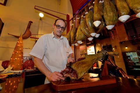 Waiter cuts ham in the "La Boveda" tapas bar, La Lonja district, Palma, Mallorca, Balearic Islands,