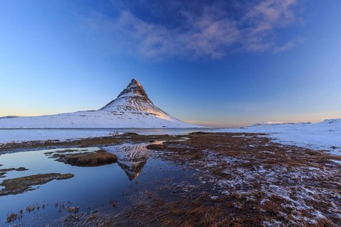 Pointed mountain reflected in fjord at low tide, snow, winter, morning light, Kirkjufell,