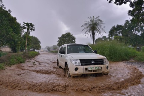 Car driving on a flooded street during the rainy season, near Makeni, Bombali District, Sierra