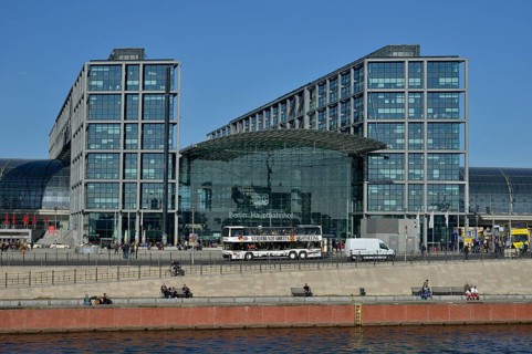 Sightseeing bus in front of Berlin Hauptbahnhof main railway station, Spree River at the front,