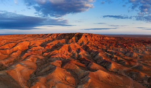 Aerial panorama of textural colorful striped canyons Tsagaan suvarga, White stupa at sunrise.