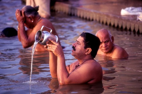 A Pilgrim pays homage to the Mother of River Ganga Ganges Ghats at Varanasi Benaras, Uttar Pradesh,