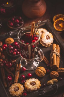 Mulled wine with cranberry and spices, Christmas cookies and candles