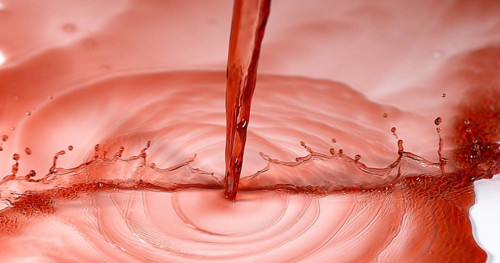 Red Wine being poured against White Background