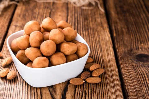 Homemade Marzipan Potatoes (German cuisine) on rustic wooden background