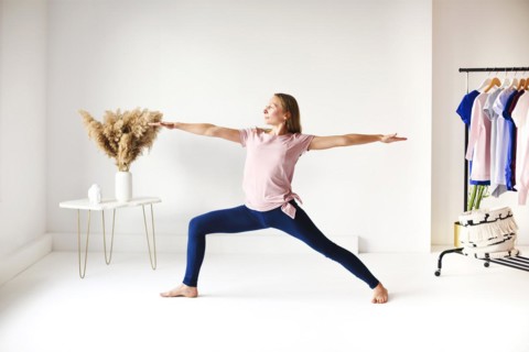 Calm female in sportswear practicing yoga in pose while balancing and looking away