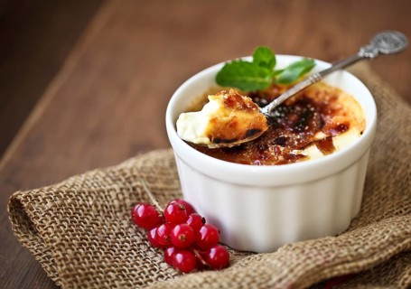 Creme brulee (cream brulee, burnt cream) with red currant and mint