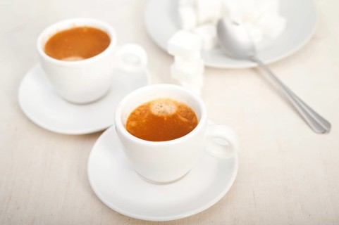 Italian espresso coffee fresh brewed macro closeup with sugar cubes