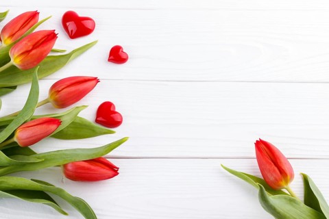 Red tulip bouquet and heart on wooden table with copy space