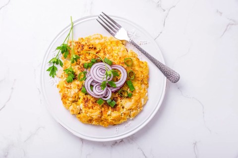 Tortilla - spanish omelet with potatoes, onions and herbs on white background