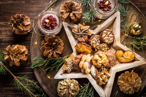 Variation of Christmas cookies and gingerbread with ornaments on wooden background