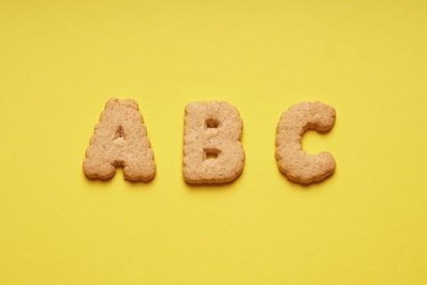 ABC cookie or biscuit letters or characters on yellow paper background