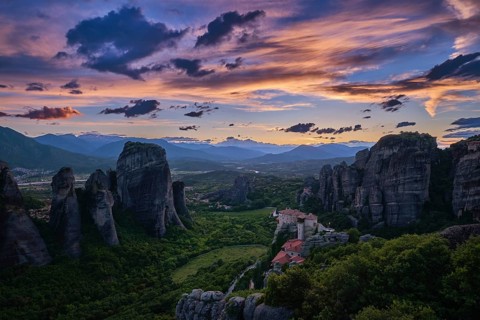Twilight view of Meteora valley. Valley in last moments of sunlight, hazy distant mountains,