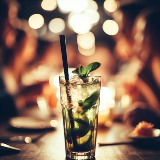 Illustration of a mojito cocktail drink in a bar pub at night, dim warm light, selective focus
