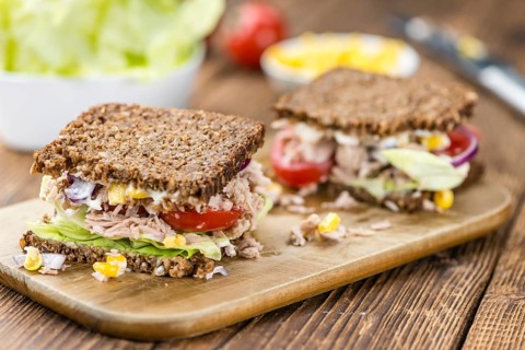 Old wooden table with Tuna sandwich (on wholemeal bread, selective focus)