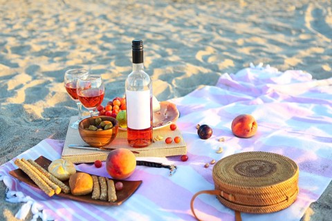 Picnic outdoor with rose wine fruits meat and cheese. Sunset